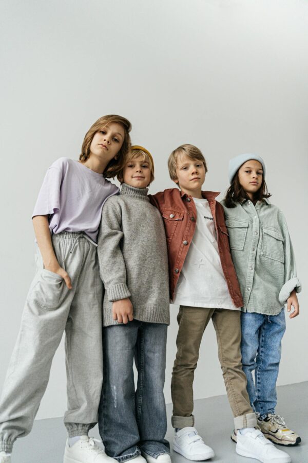 Stylish group of children posing in winter fashion attire indoors.